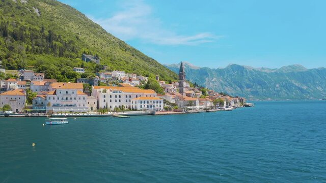 Drone flying over the the St. Nicholas Church and cityscape in Perast, Montenegro. Amazing blue sea and magnificent mountains