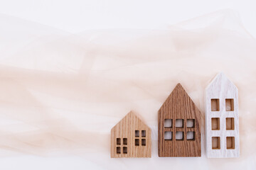 wooden houses on off white sheer fabric. Cozy home background. flat lay  sustainable home concept.