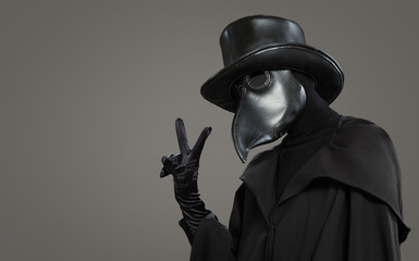 The plague doctor shows a positive gesture on a gray background.