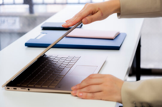 定時なので業務を終わらせノートPCを閉める女性【2020】