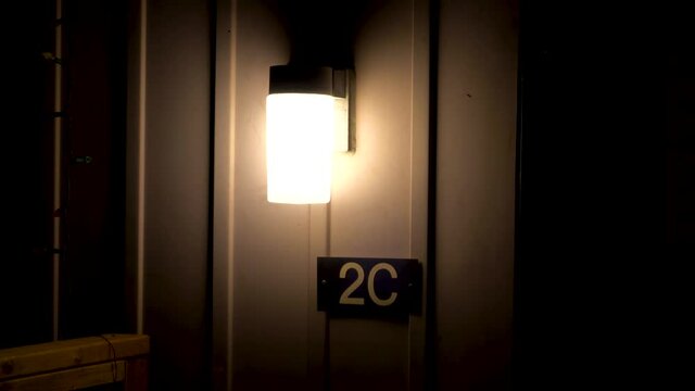 House number 2C under a light at night.