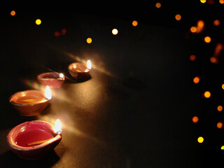 Diya or deep burning arranged in row on black background with Space for text ,Happy diwali wallpaper - obrazy, fototapety, plakaty