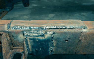 Car Chassis Repair by Electrode Arc Welding in Car Repair Shop in Zoom View in Vintage Tone