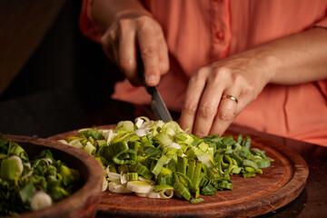 Closeup shot of a woman chopping green onion
