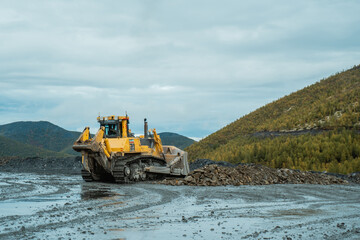 The bulldozer works at the gold mining site. © CjVitoS
