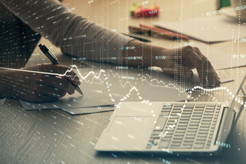 Double exposure of businesswoman hands typing on computer and forex chart hologram drawing. Financial analysis concept.