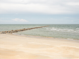 empty sandy tropical beach. wide beach on island. copy space provided. wave breaker on shore.