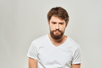 Obraz premium man in white t-shirt gesturing with his hands studio dissatisfaction lifestyle light background