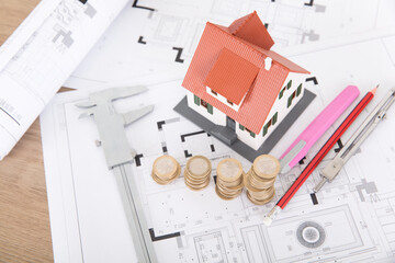 Interior design or housing construction design related drawings and a row of incremental coins and related tools