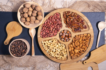 nuts peanuts, hazelnuts, almonds, cashews, walnuts, pecans on a wooden table. Top view with space for your text
