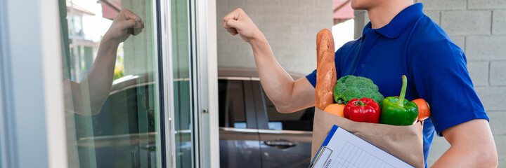 Asian deliver man in uniform is delivering the paper bag waiting for the customer in front of the home, Food delivery service.