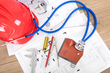 Looking down and shooting engineering drawings and a hard hat and other related tools with a...