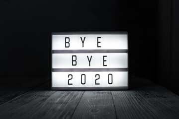 Lightbox with text BYE BYE 2020 in dark room. Hope, new life and Happy New Year 2021 concepts