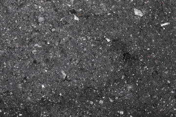 texture of old gray asphalt with a crack and small stones