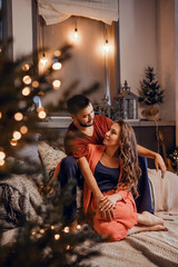 A young couple celebrates Christmas in a cozy country house concept of Winter holidays and Family holidays. Festive atmosphere.