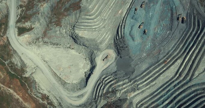Panorama aerial view shot of opencast coal mining, quarrying extractive industry stripping work. Mining Trucks parked in the middle