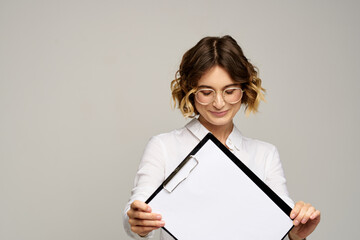 Naklejka premium Business woman in a light shirt and a folder with documents in hands cropped view of work