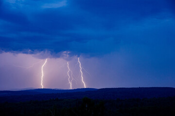 Naklejka na ściany i meble Dangerous thunderstorm lightning on the night in a village field in summer