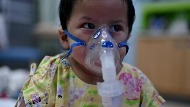 Asian baby was sick as Respiratory Syncytial Virus (RSV) in kid hospital. Thai little girl having inhaler containing medicine for stop coughing and disease flu.