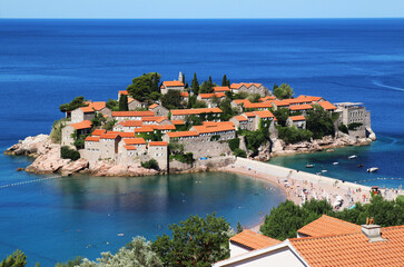 Sveti Stefan island in Montenegro. Adriatic coast with clear blue sea water.  Magnificent hotels and comfortable beaches of the Budva Riviera.