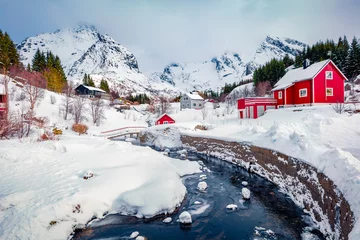 Foto op Canvas Snowy winter cityscape of Nusfjord town. Fabulous landscape of Norway, Europe. Amazing morning view of Lofoten Islands with red wooden houses and small river. Life over polar circle. © Andrew Mayovskyy