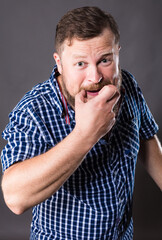 Joyful bearded man in shirt whistling studio portrait