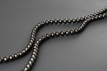 Black beads on a black background. Black on black.