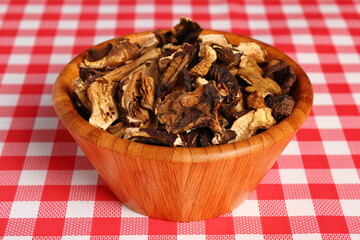 Dried mushrooms in wooden bowl. Boletus badius.