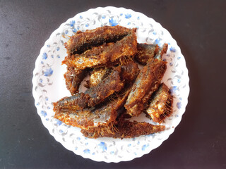 delicious Kerala style fish fries in a plate on black background