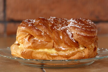 Eclair filled with pastry cream (custard) and topped with icing sugar