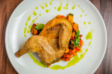 Half of the chicken with vegetable caponata, top view, close up