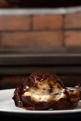 Profiterole with chocolate ganache frosting.  Choux pastry ball with custard filling and chocolate sauce icing.