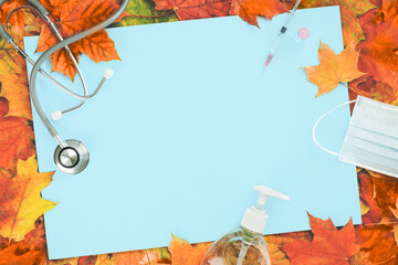 Flu and cold season frame on blue with fall leaves. Flu season or second wave. Face protective...
