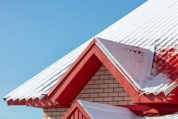 Snow on the roof of the house.