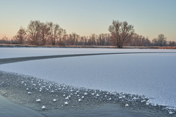 Breath of winter, first ice on the lake, dawn on a frosty morning with frost on the grass, close-up of frost, patterns on the first ice.