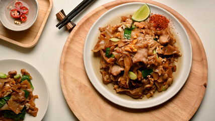 Stir fried Noodle with sweet soy sauce (Pad See Ew) on wooden tray
