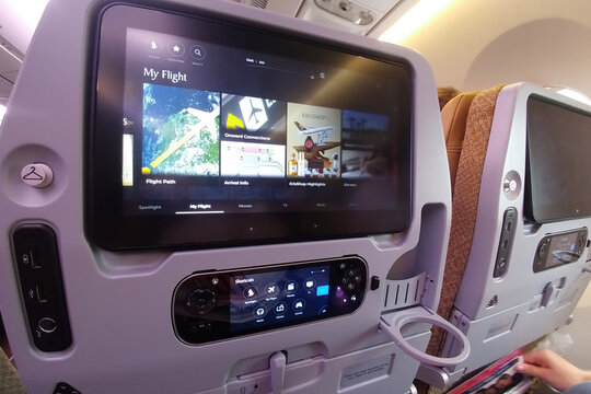 Singapore - May 06, 2019: Modern multimedia system of the aircraft located in the passenger seats. Large monitor in the back of the chair with a joystick for playing and control. Singapore airlines