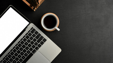 Naklejka premium Black concept workspace with laptop, coffee cup and copy space, include clipping path