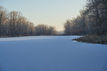 Breath of winter, first ice on the lake, dawn on a frosty morning with frost on the grass, close-up of frost, patterns on the first ice.