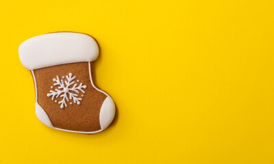 Christmas stocking shaped gingerbread cookie on yellow background, top view. Space for text