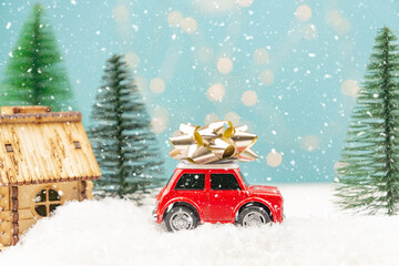Christmas or New year card with toy car and christmas tree miniature and Christmas bokeh lights on background