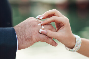 Hands of groom and bride at wedding day. Bridal couple hugging. Wedding love and family concept close up macro photo with selective focus