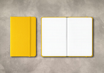 Yellow closed and open lined notebooks on concrete background