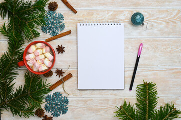 Christmas or new year in a cozy home lifestyle, write down plans for the future, sum up the results in a cozy evening, a cup of cocoa with marshmallow anise and cinnamon, decorations on the table