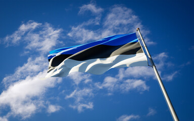 Beautiful national state flag of Estonia fluttering at sky background. Low angle close-up Estonia...