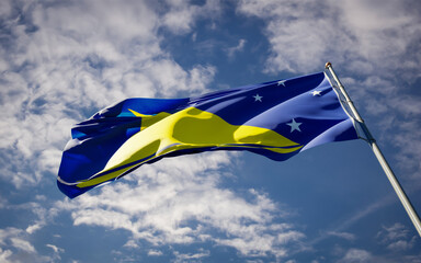 Beautiful national state flag of Tokelau fluttering at sky background. Low angle close-up Tokelau flag 3D artwork.