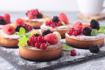 Fresh small homemade fruit tarts with raspberries, currants and blackberries