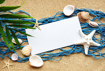 Empty blank of sheet paper on beach sand with sea shells