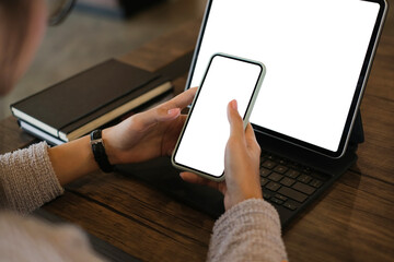 Cropped shot of woman hands using mobile phone and tablet computer with blank copy space screen for your advertising text message or content business.