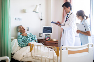 Obraz premium 入院中の高齢男性と回診に来た医師、女性看護師